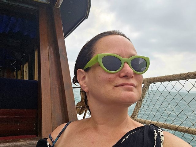 Sarah in green sunglasses on a boat